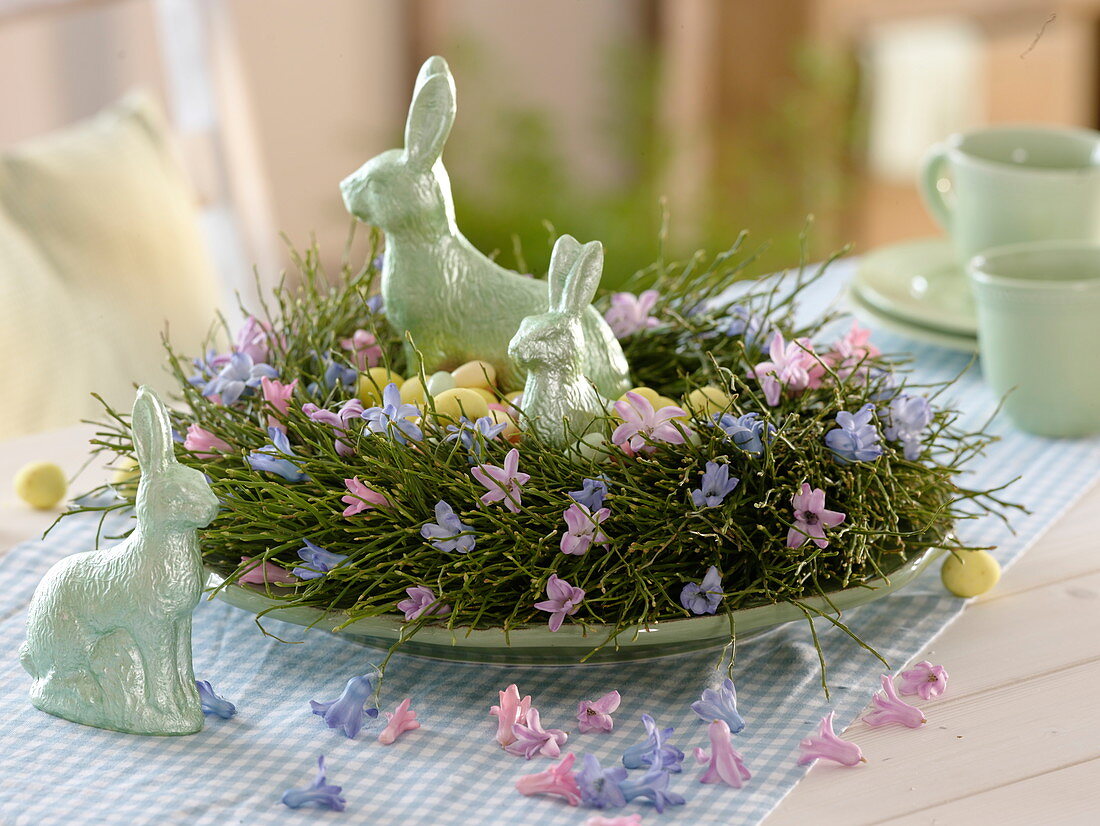 Wreath of Vaccinium (blueberry branches) as Easter nest with ceramic bunnies