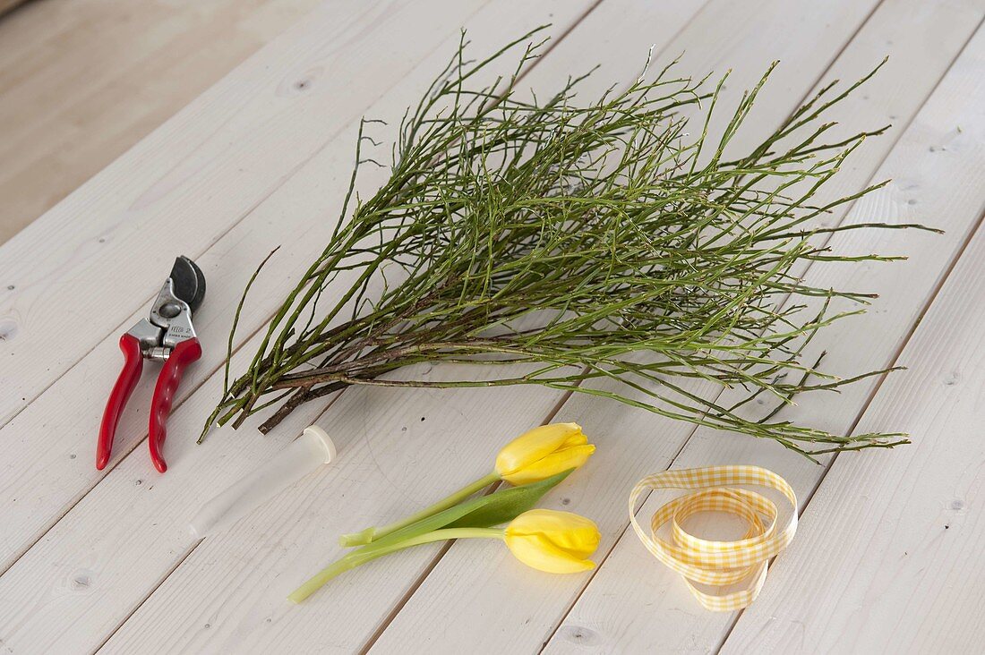 Table decoration with yellow tulips and blueberry branches