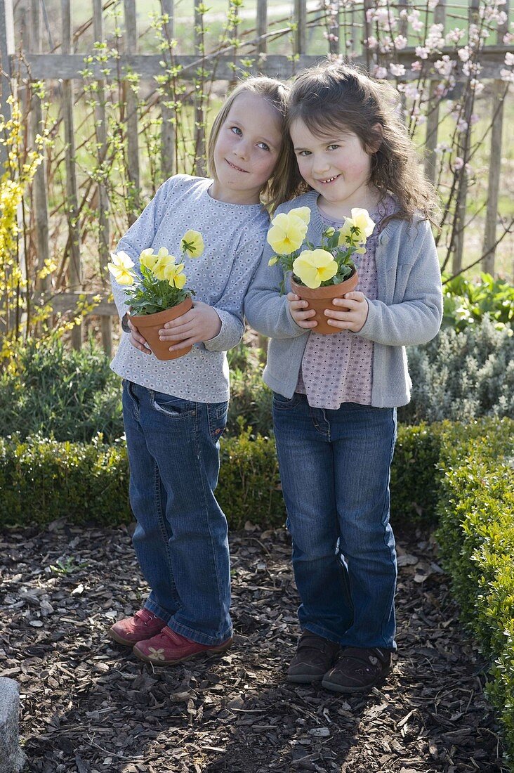 Girl in the farm garden with pansies