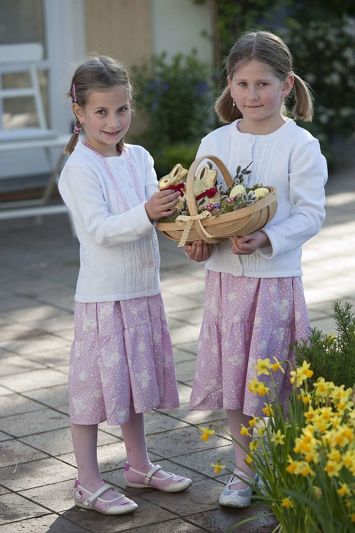 Girl with Easter basket: chocolate Easter bunny, Easter eggs, lucky beetle