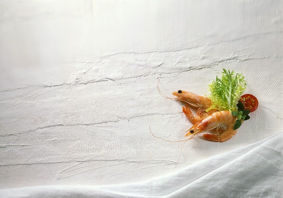 Zwei Crevetten mit Salatdeko auf weißem Hintergrund