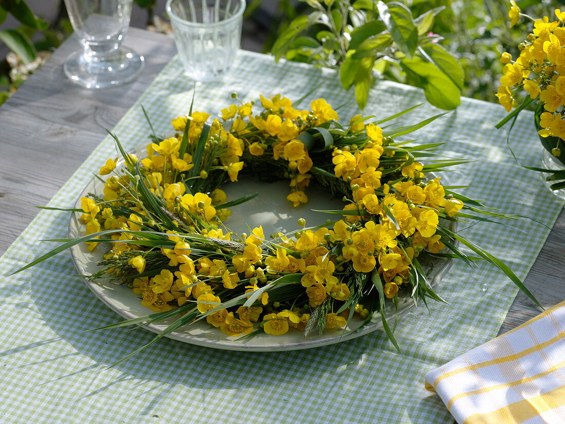 Sharp buttercups and grasses as a plate wreath