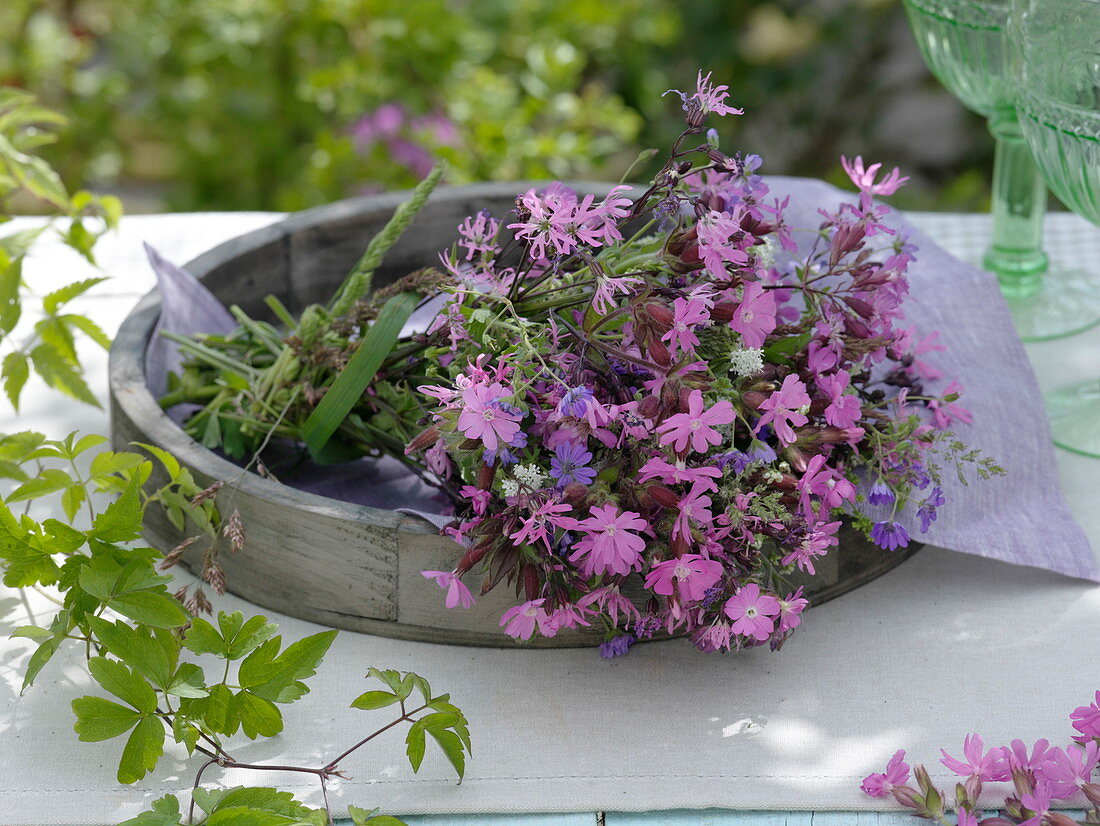 Pink meadow flower bouquet on wooden tray