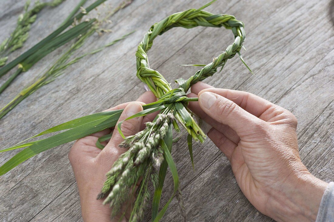 Braided heart of grasses with chamomile flowers