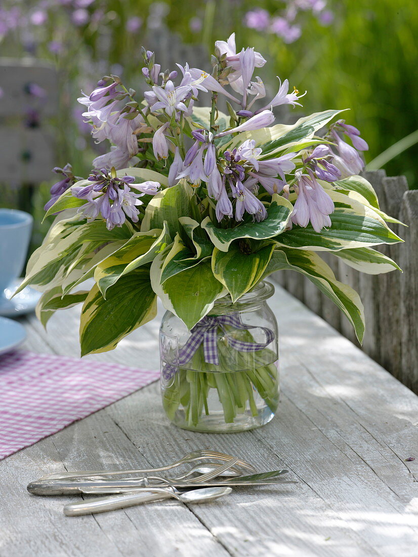 Bouquet of flowers and leaves of the hosta (Funkie) in mason jar