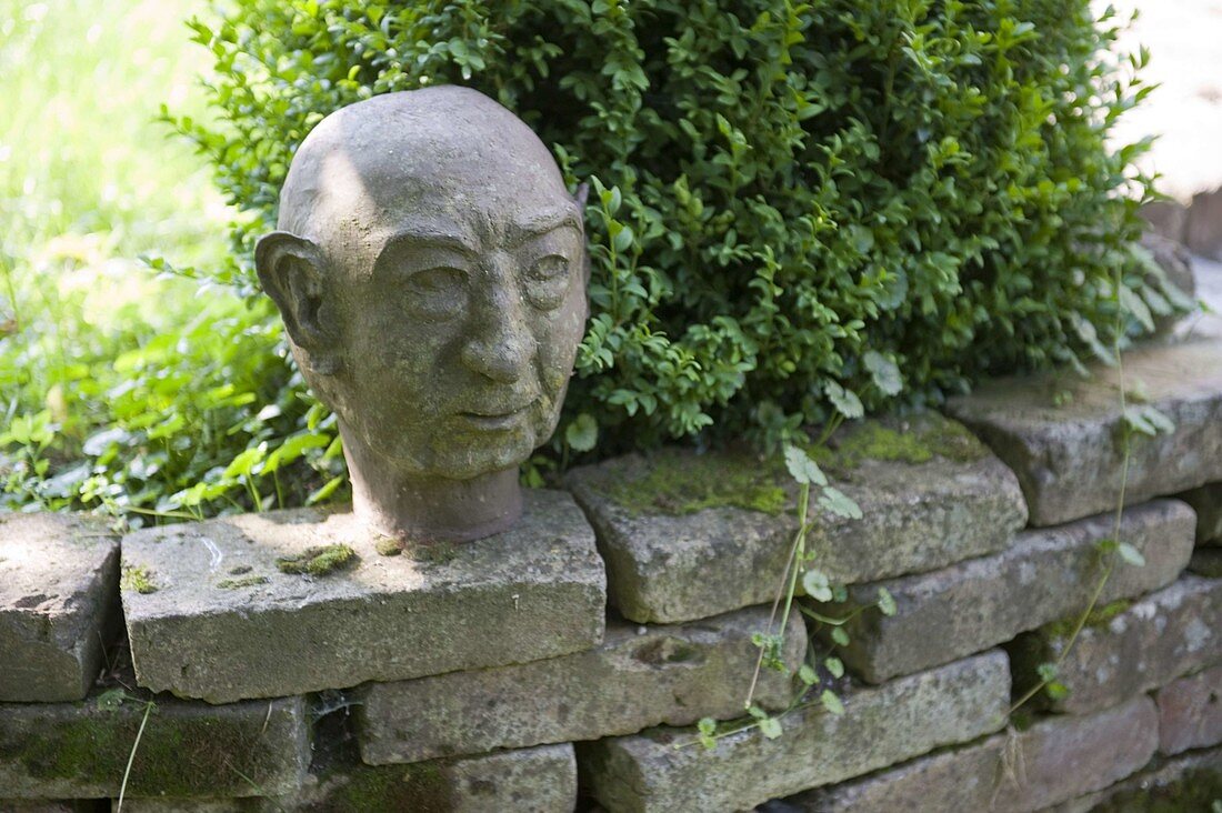 Artist's garden with head on wall