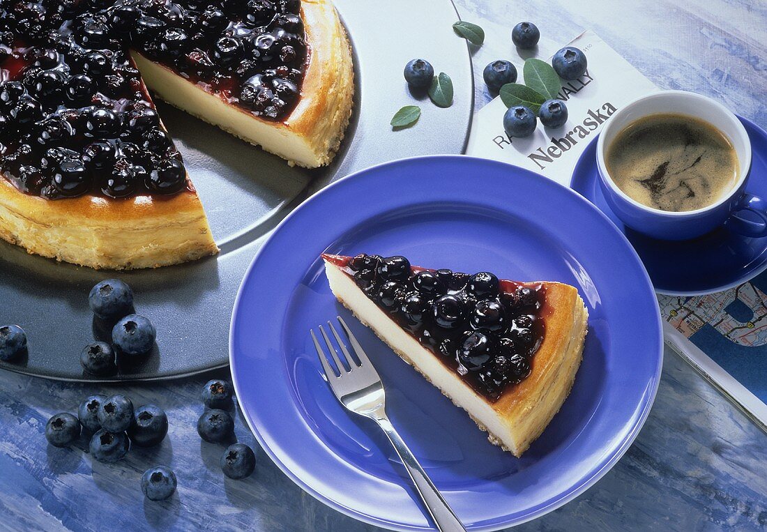 A piece of blueberry cake on plate & cake with pieces cut