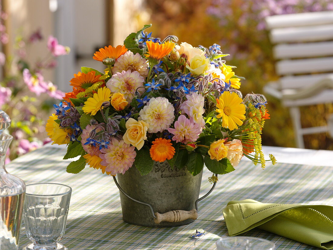 Colourful late summer bouquet in tin can: Dahlia (Dahlias), Calendula