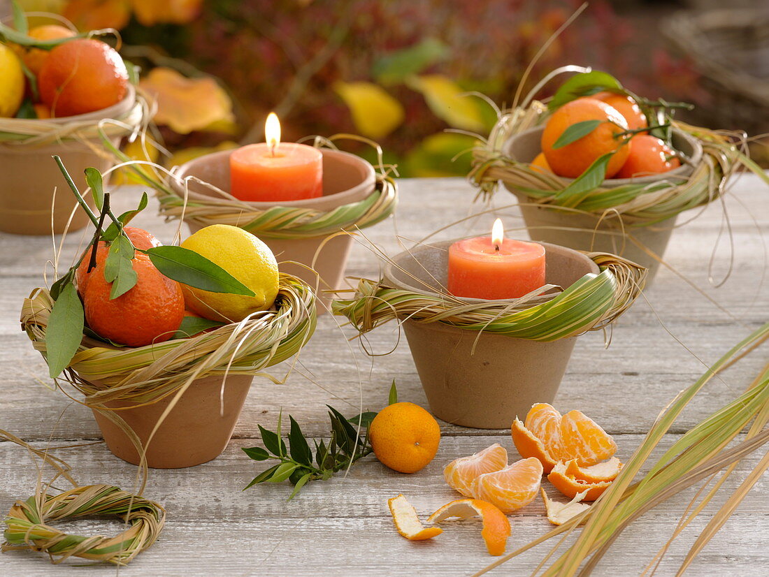 Autumnal fruit decoration with mandarins and lemons (citrus), candles