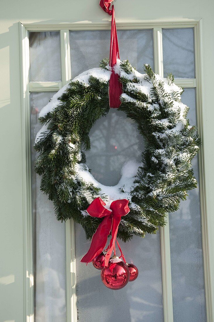 Snowy garden house decorated for Christmas with wreaths