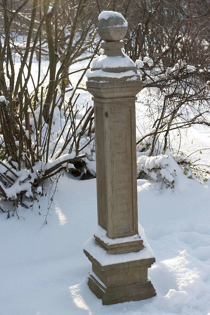 Snowy stone column with ball
