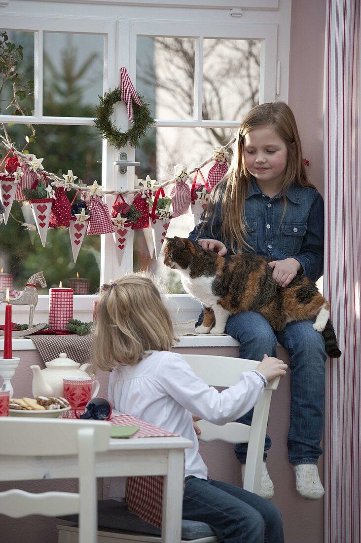 Girl with advent calendar at window