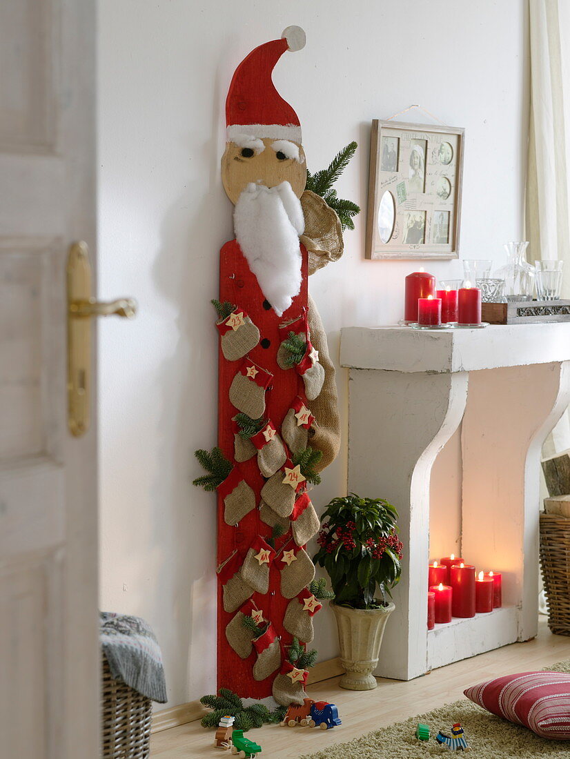 Wooden Father Christmas hung with numbered bags as an Advent calendar