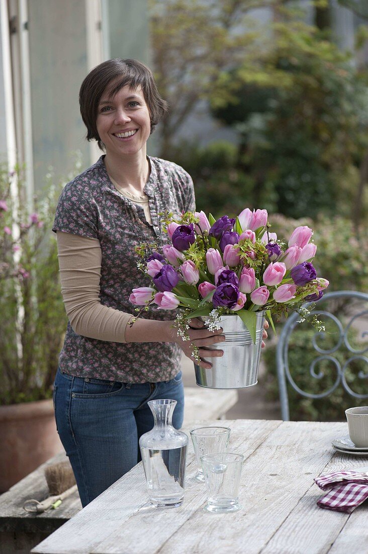 Woman with spring bouquet of tulips and woody branches