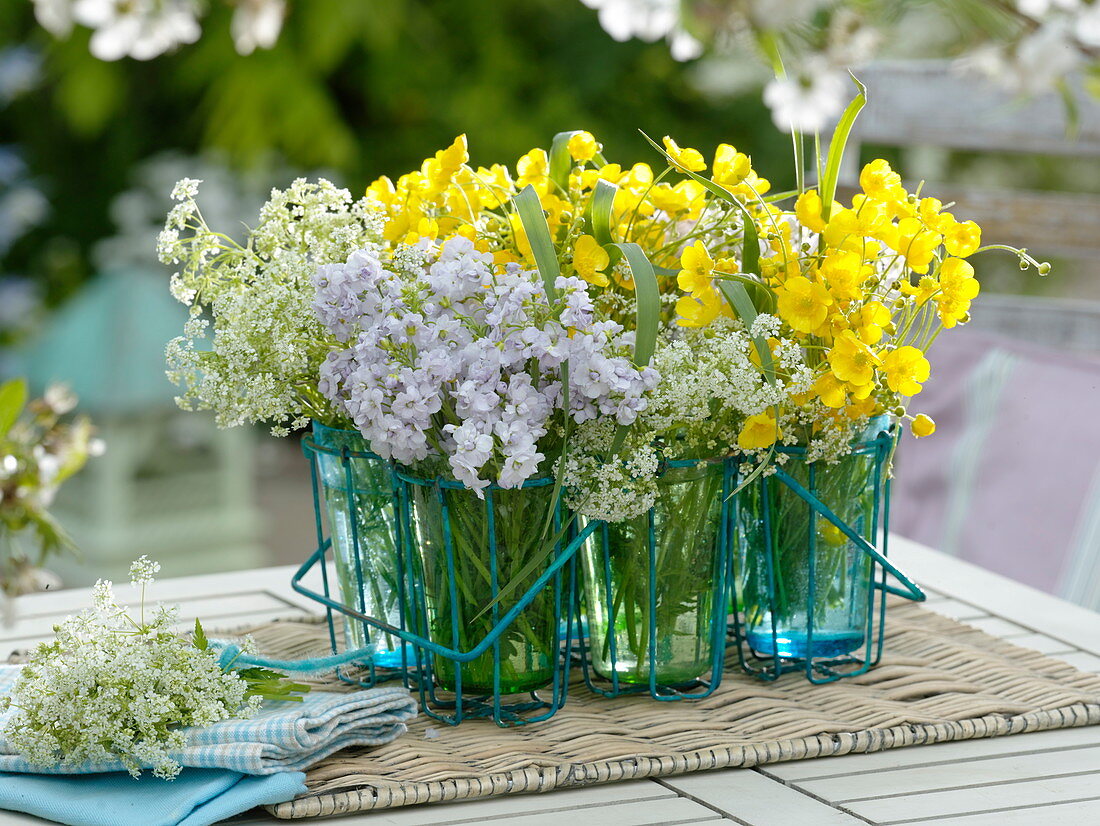 Meadow flowers in glasses in a wire frame: Cardamine (meadow foamwort)