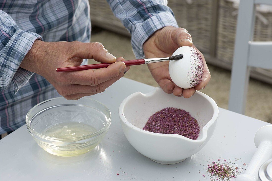 Sticking Easter eggs with crushed flowers