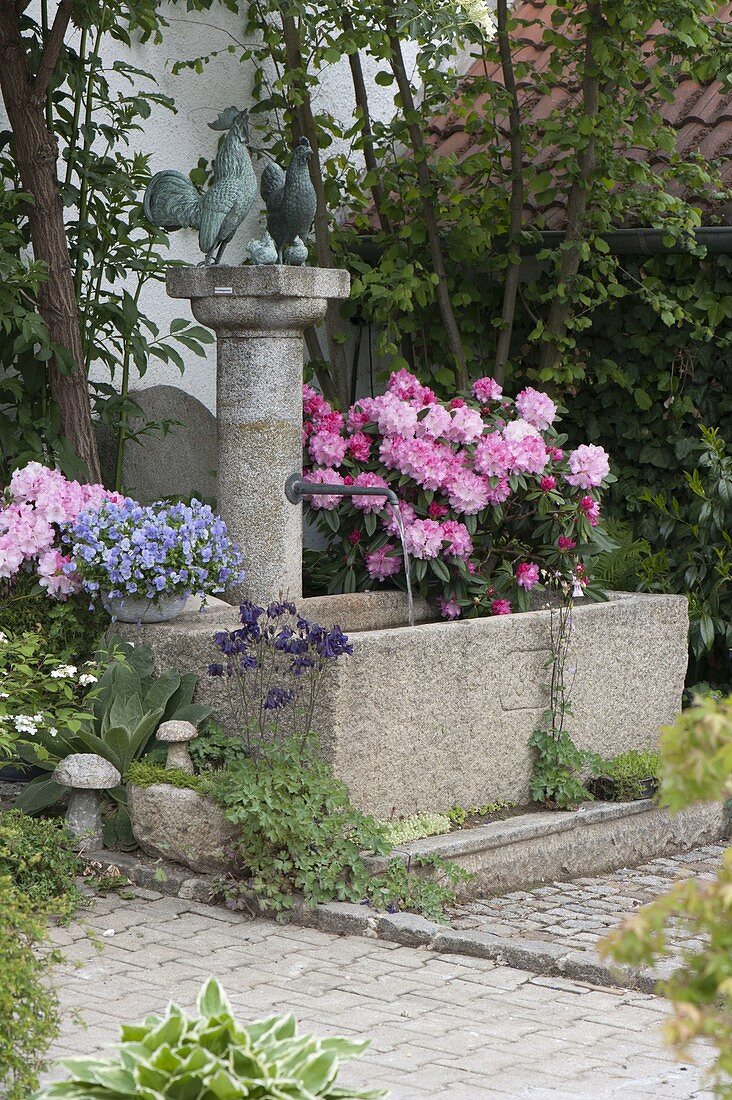 Granite fountain with metal cock, hen and chick on the column