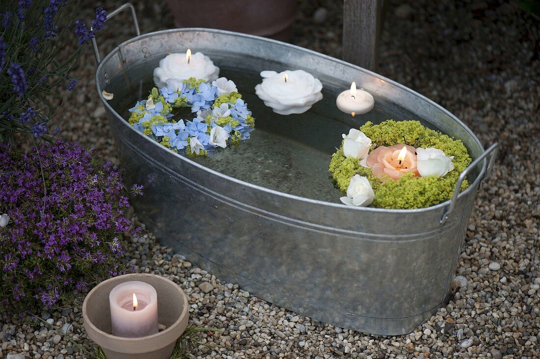 Wreaths and floating candles in a tub of water