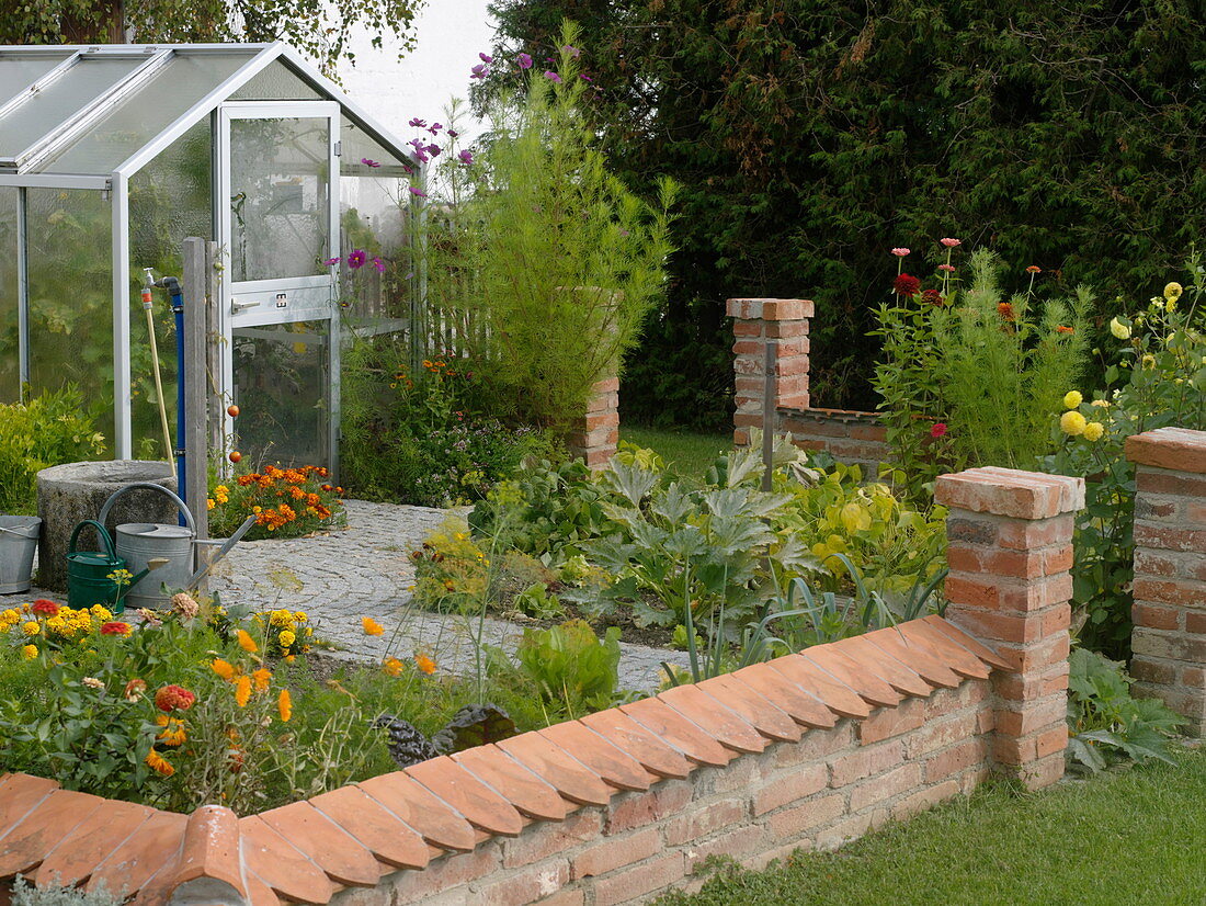 Small cottage garden with wall and greenhouse