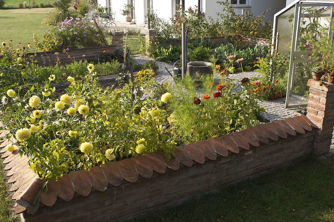 Small cottage garden with wall, fountain in the middle, paved paths