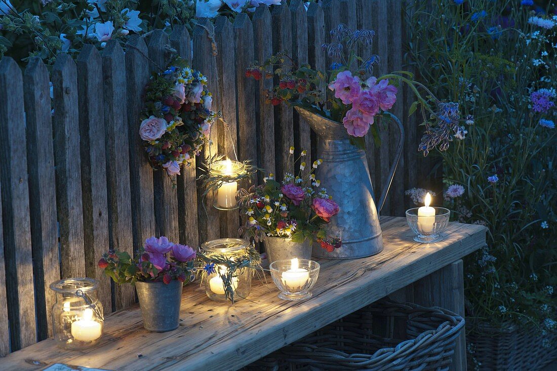 Abendliches Arrangement mit Windlichtern, Sträußen und Kranz aus Rosa