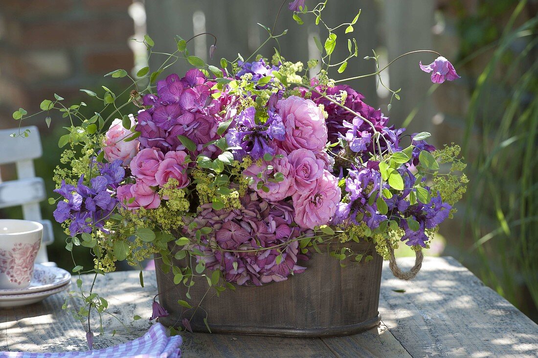 Summer arrangement with roses, hydrangea, alchemilla