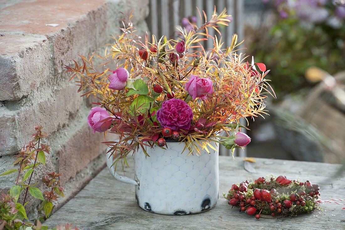 Autumn bouquet of pink (roses and rose hips) and Spiraea branches