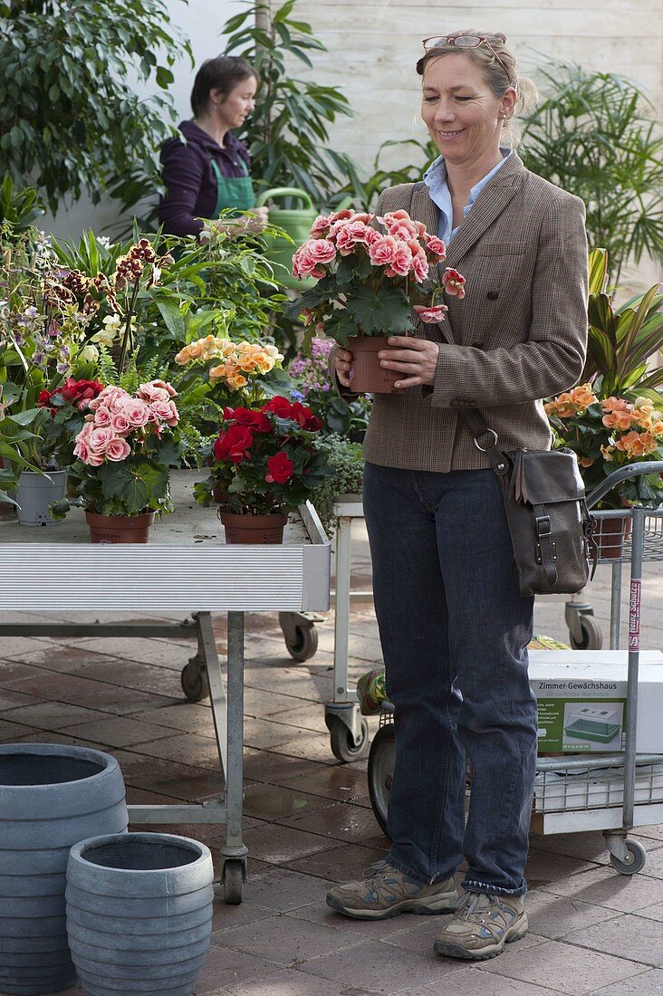 Woman buying flowers at garden centre