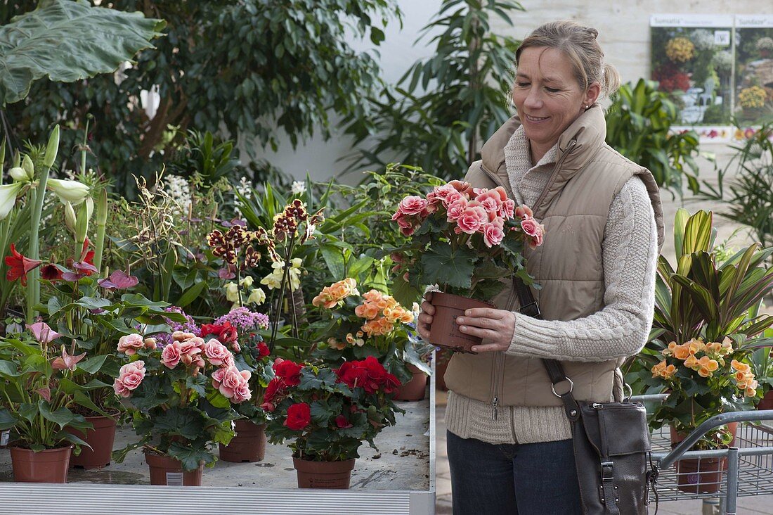 Frau kauft Blumen im Gartencenter