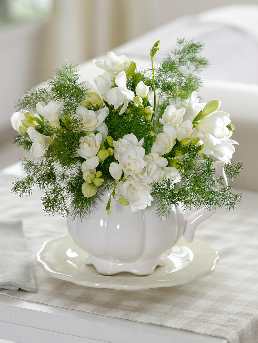 Small bouquet of freesia (freesias) in a white cup