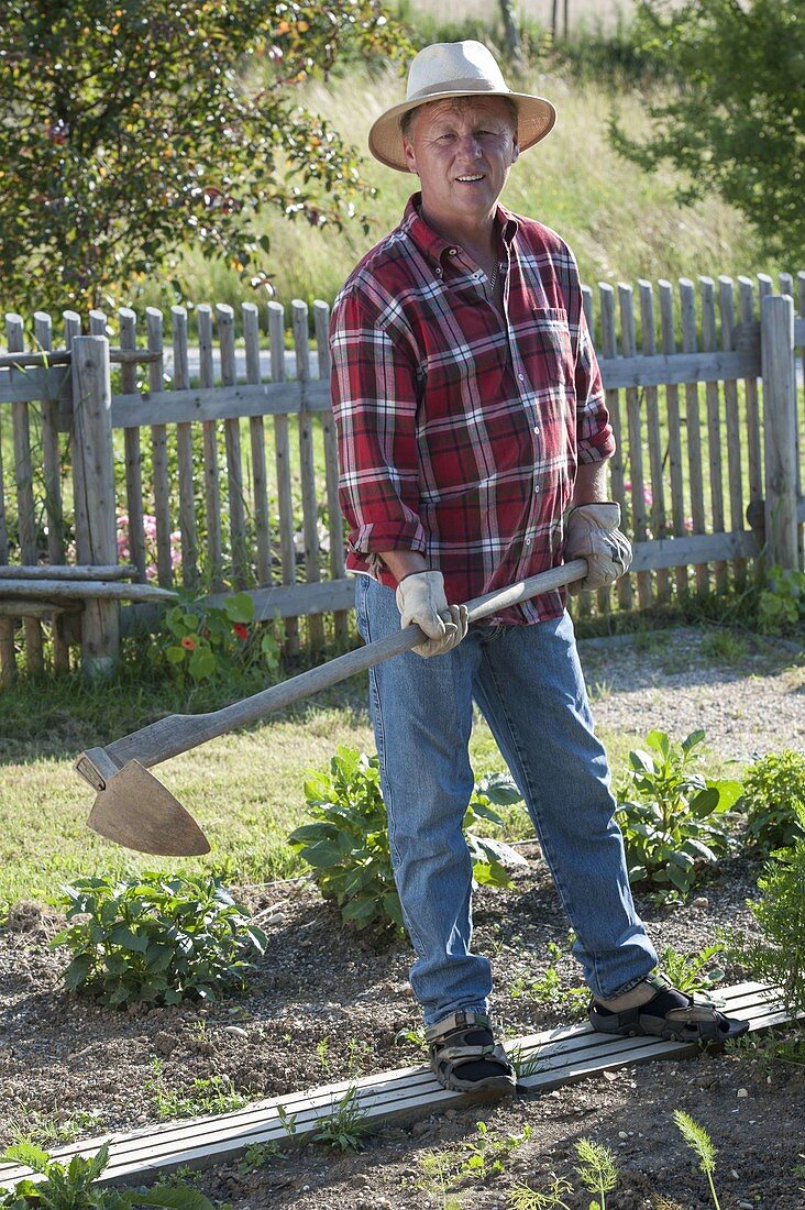 Man with hoe in organic garden