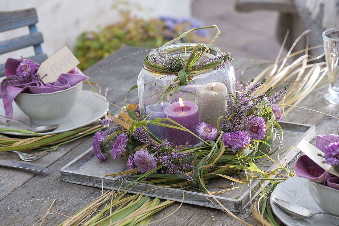 Autumn table decoration with grasses, heather and chrysanthemum flowers