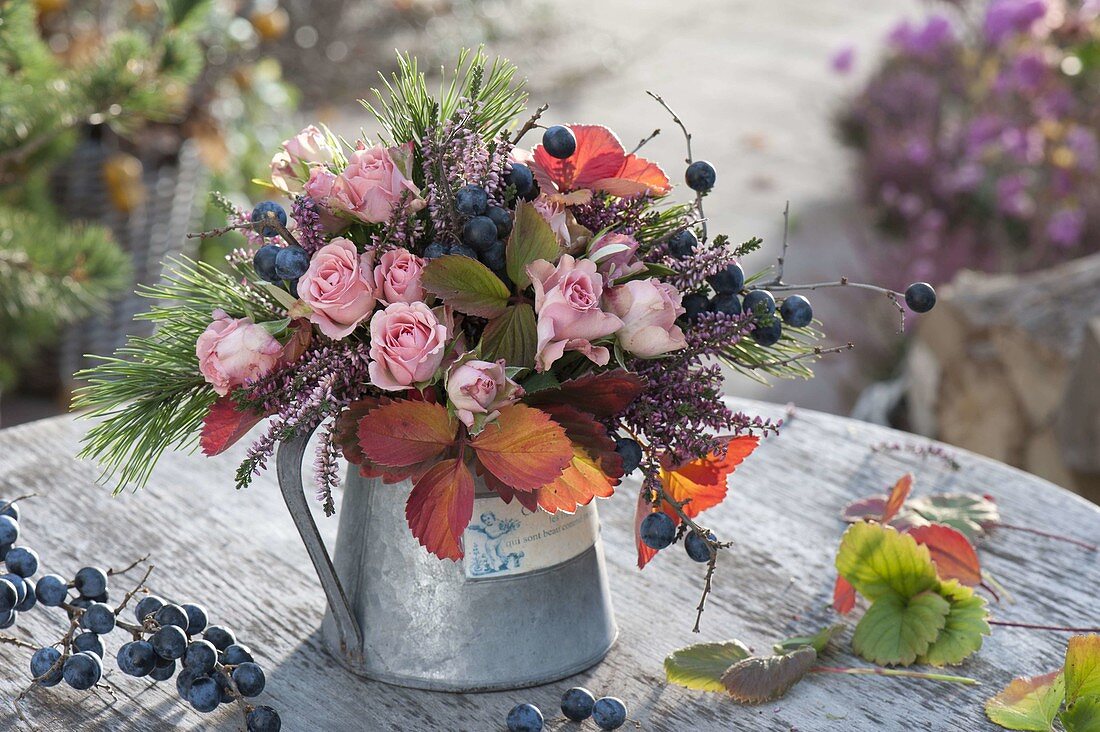 Autumn bouquet of pink (roses), pine (Pinus), blackthorn (Prunus spinosa)