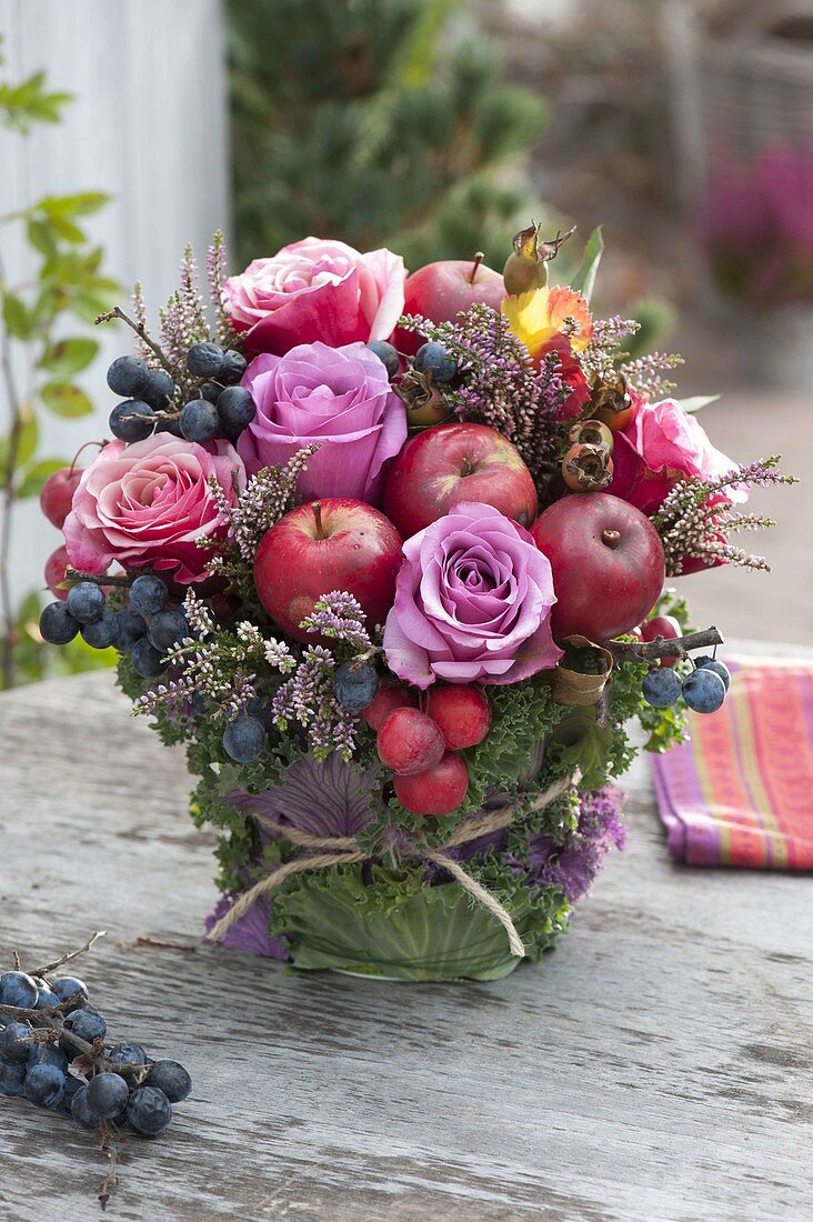 Herbstlicher Strauss mit Rosa (Rosen), Äpfeln und Zieraepfeln (Malus)