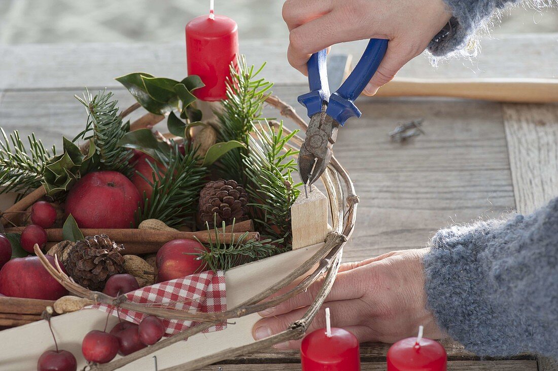 Obstiege als ungewöhnlicher Adventskranz gefüllt mit Äpfeln