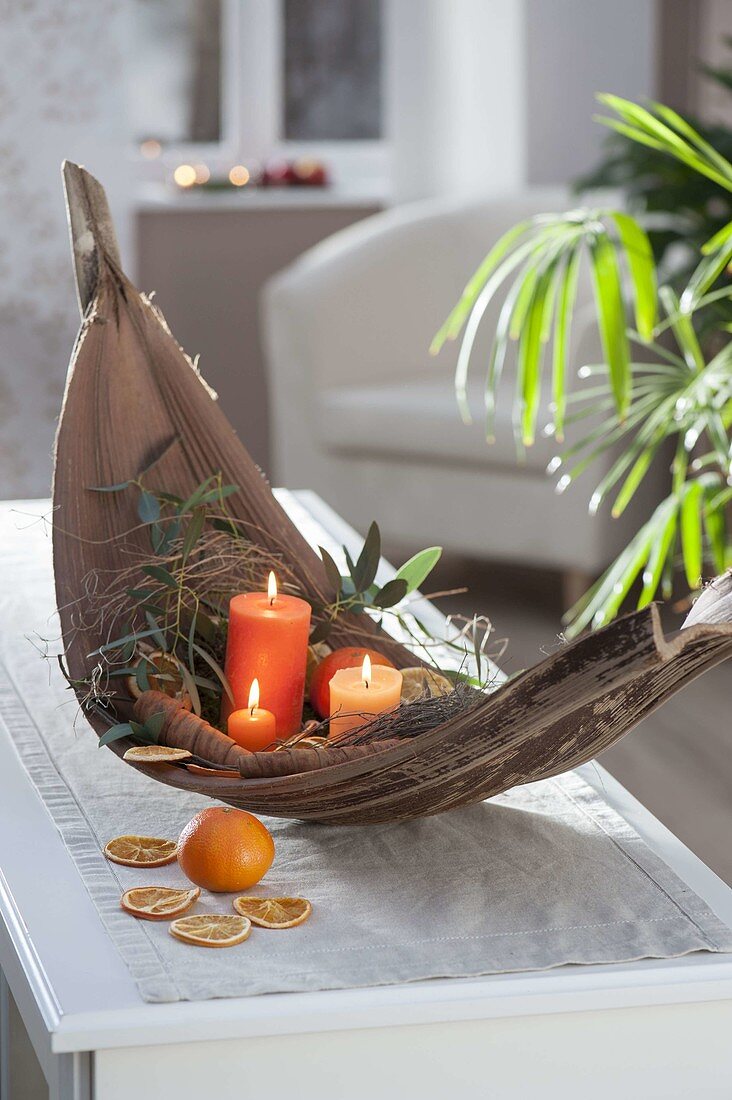Bowl of palm leaf with candles, oranges (Citrus sinensis)