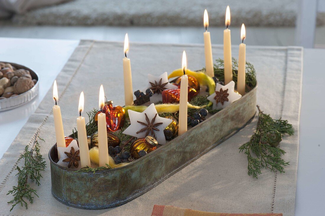 Christmas candle decoration in elongated metal bowl
