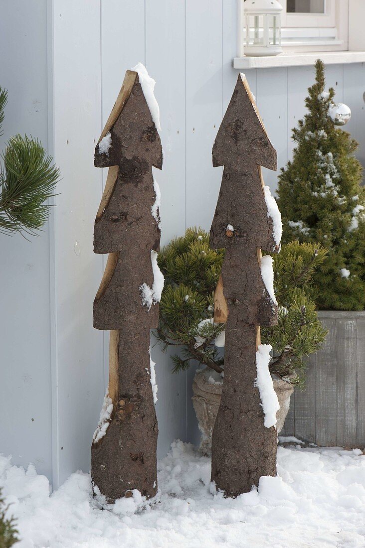 Stylised Christmas trees cut out of boards with bark