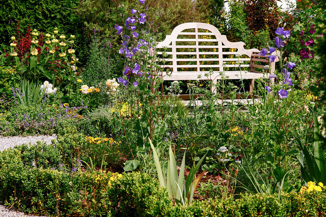 Classic English garden bench Sissinghurst between flower beds