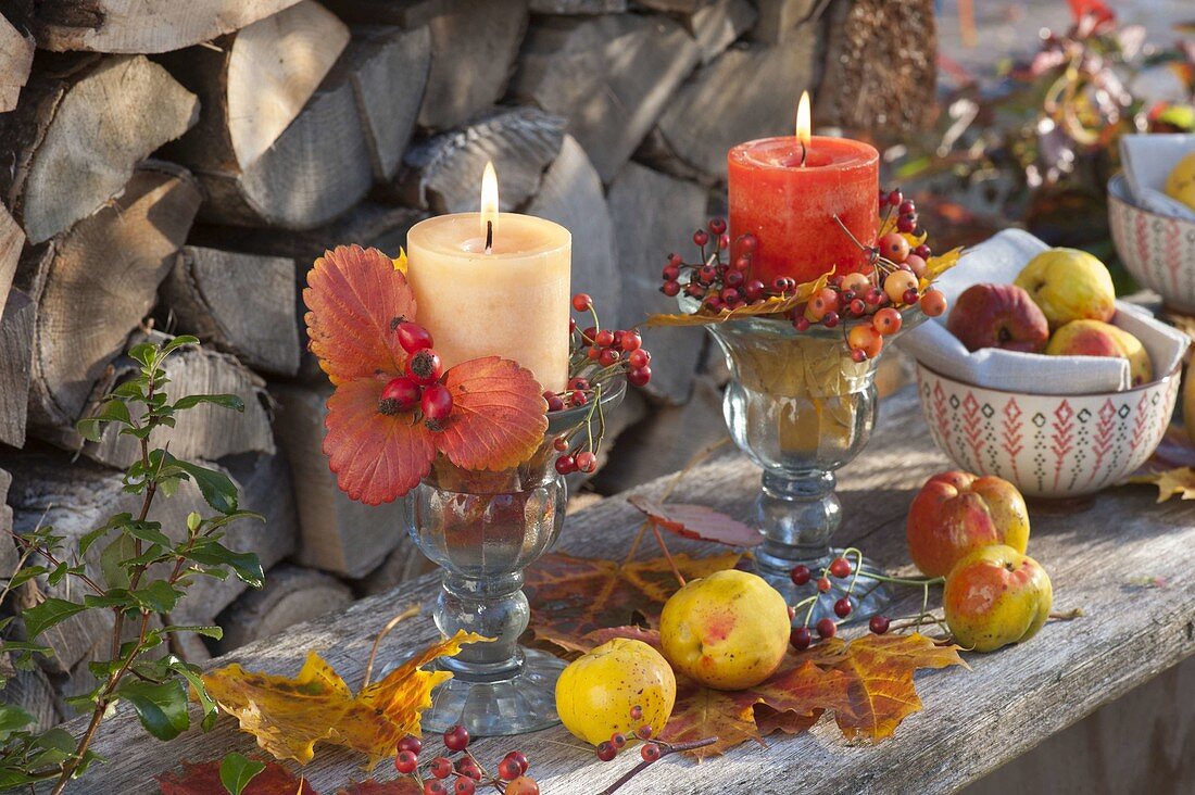 Autumnal candle decoration with leaves, pink (rosehips) and chaenomeles