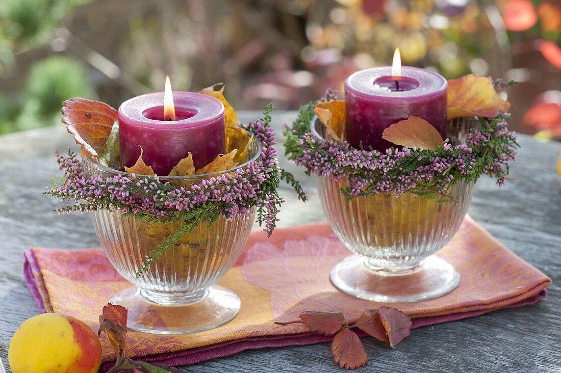Autumn candle decoration in glasses with strawberry leaves