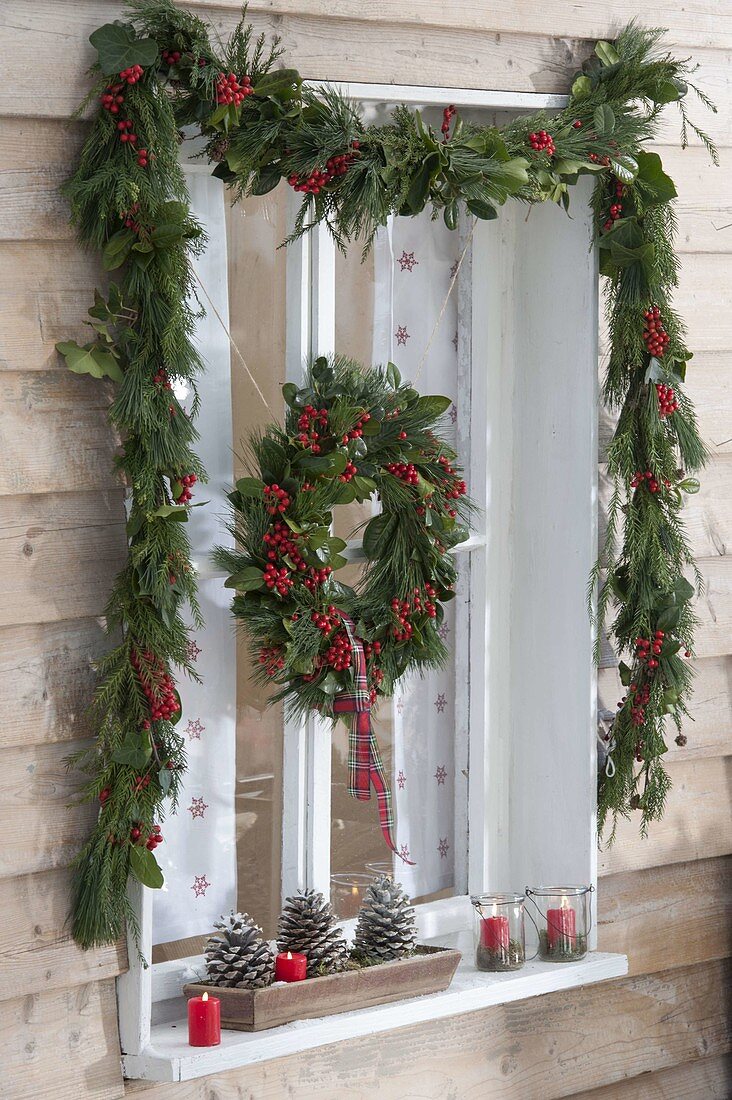 Decorate window with garland and wreath for Christmas