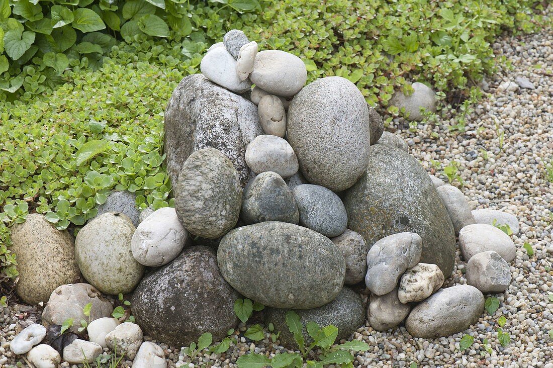 Pebbles stacked on flower bed as a stone sculpture