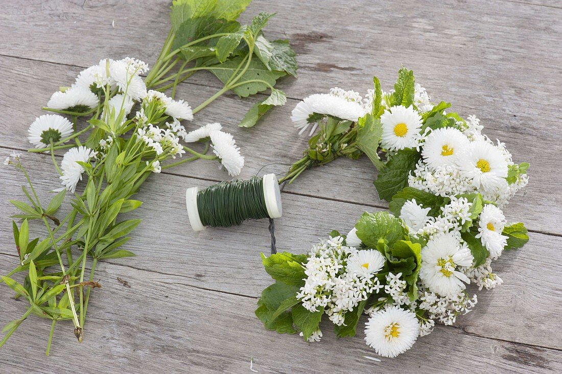 Tying a wreath of daisies and herbs