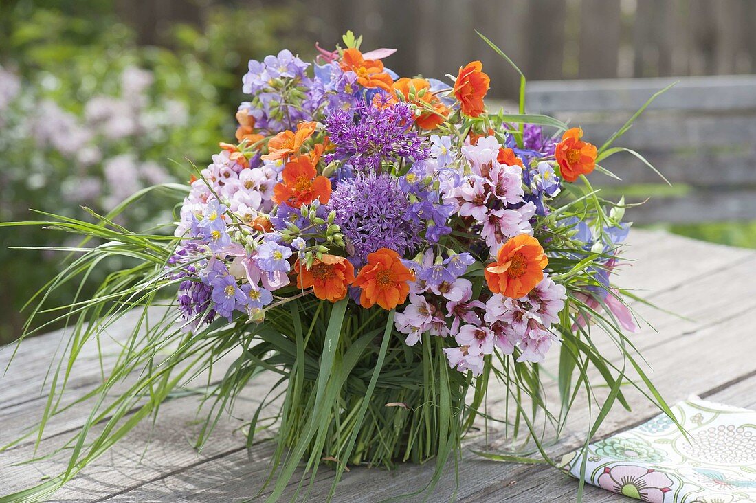 Colorful spring bouquet in grass coat vase