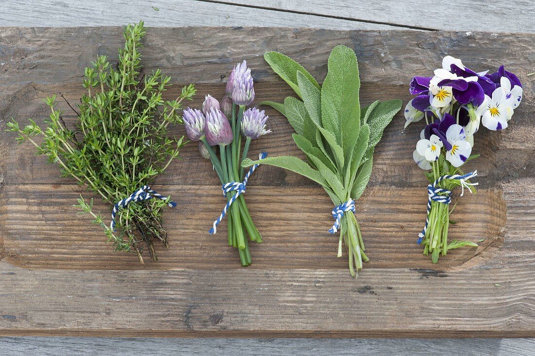 Tying a small wreath of herbs and edible flowers