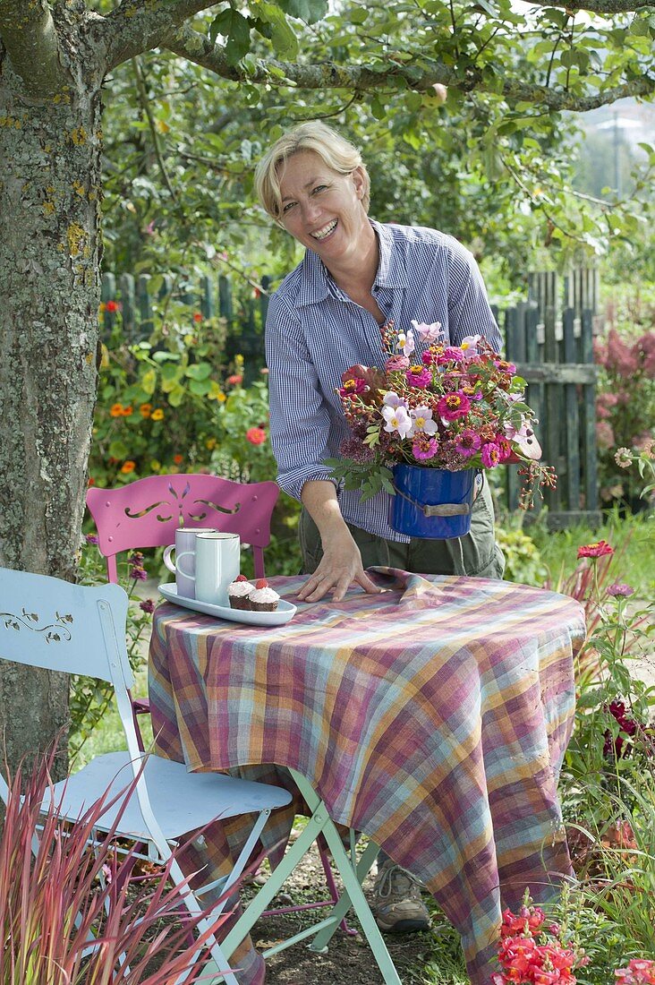 Woman covering table under apple tree