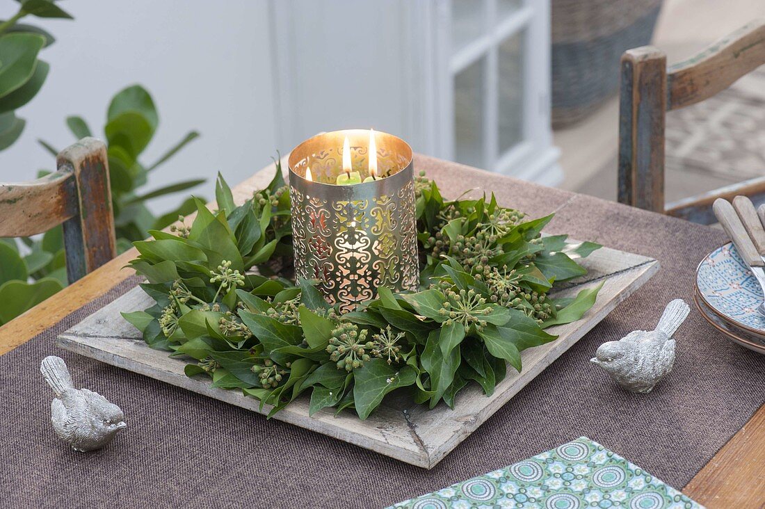 Wreath made of hedera (ivy) with fruit stalks on wooden coasters