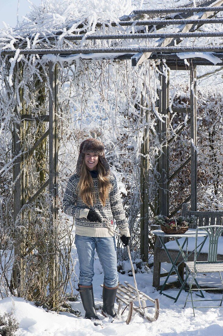 Wooden pavilion with hoarfrost covered in snowy garden