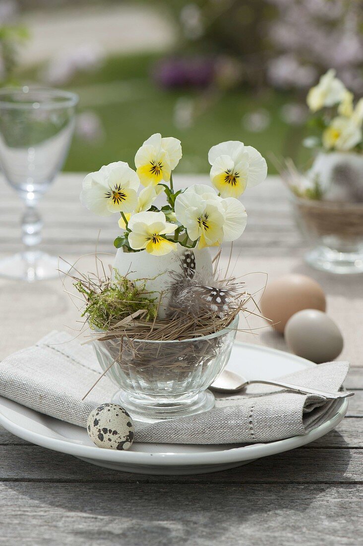 Easter table decoration with horned violets on the terrace